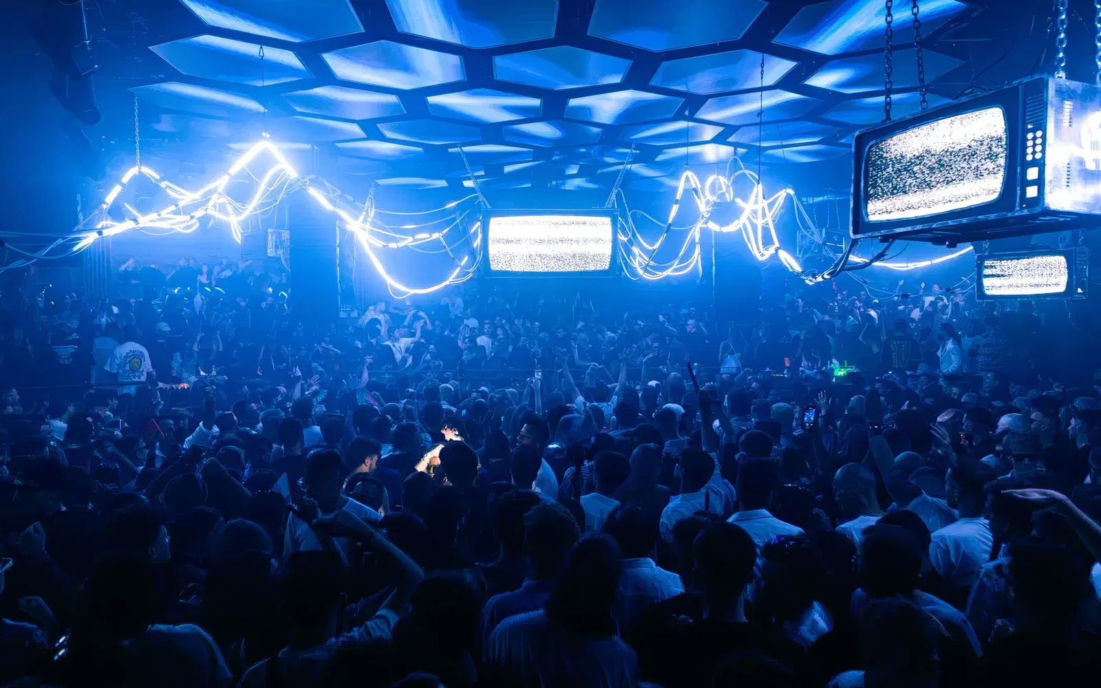 DJ performing at Music On event, Pacha Ibiza nightclub, with vibrant crowd and neon lights.