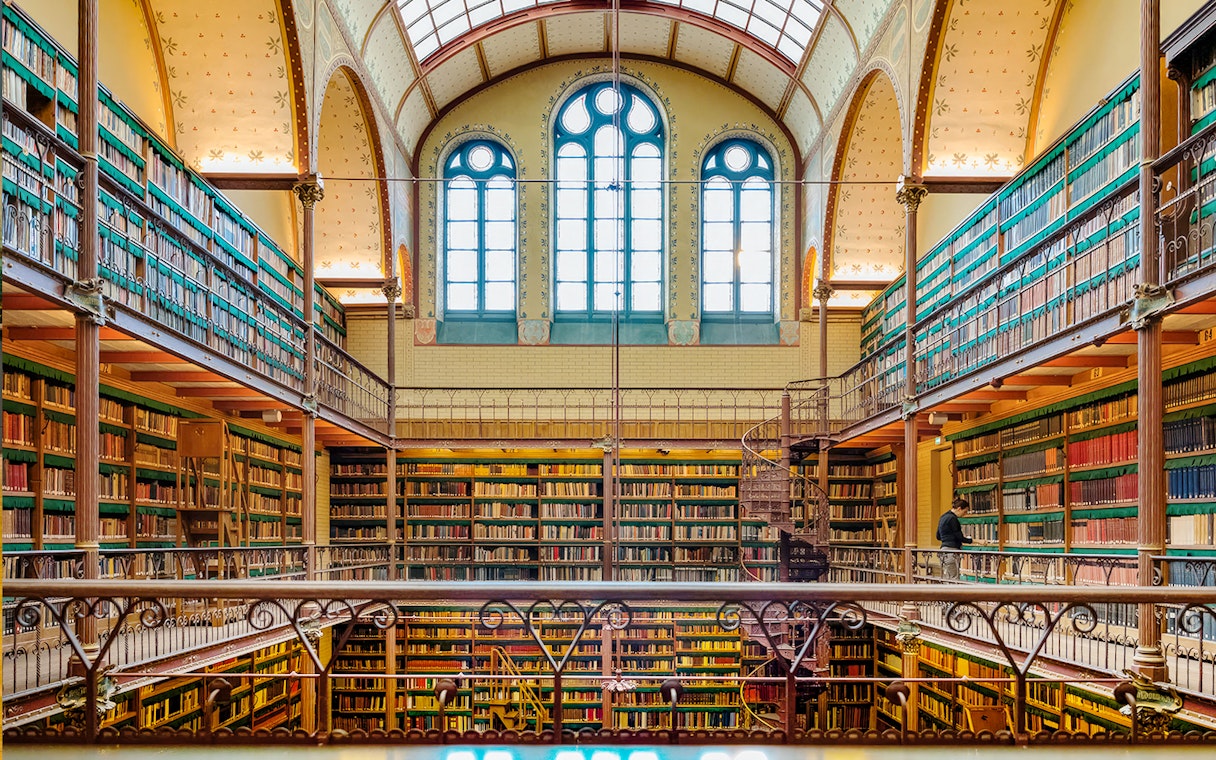 Rijksmuseum library interior with spiral staircase and bookshelves, Amsterdam.