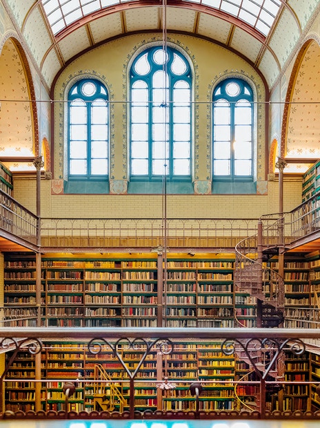Rijksmuseum library interior with spiral staircase and bookshelves, Amsterdam.
