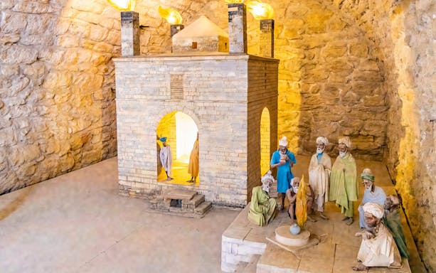 Teshgah Fire Temple interior with stone structure and figures in Azerbaijan.
