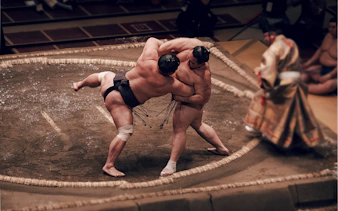 Sumo wrestlers competing in the Fukuoka Grand Sumo Tournament with a local guide.