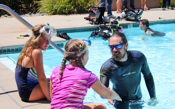 Scuba instructor teaching children in a pool at Palm Jumeirah, Dubai.