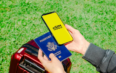 Passport and smartphone with eSIM over suitcase, related to Vietnam E-Visa service, Nha Trang.