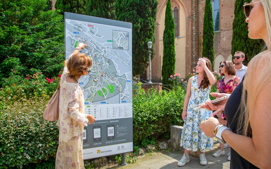 Tour group examining a map in Siena, Tuscany during the Semi Private Tuscany Grand Tour.