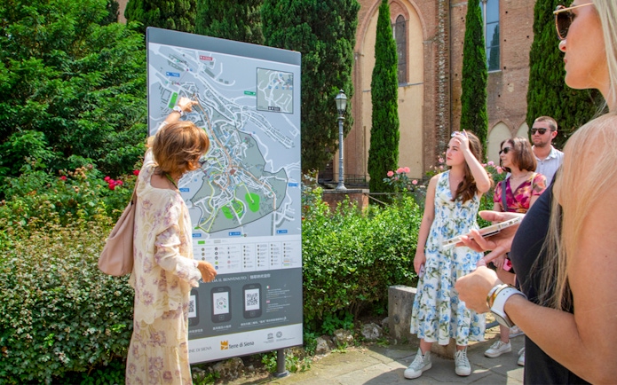 Tour group examining a map in Siena, Tuscany during the Semi Private Tuscany Grand Tour.