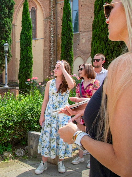 Tour group examining a map in Siena, Tuscany during the Semi Private Tuscany Grand Tour.