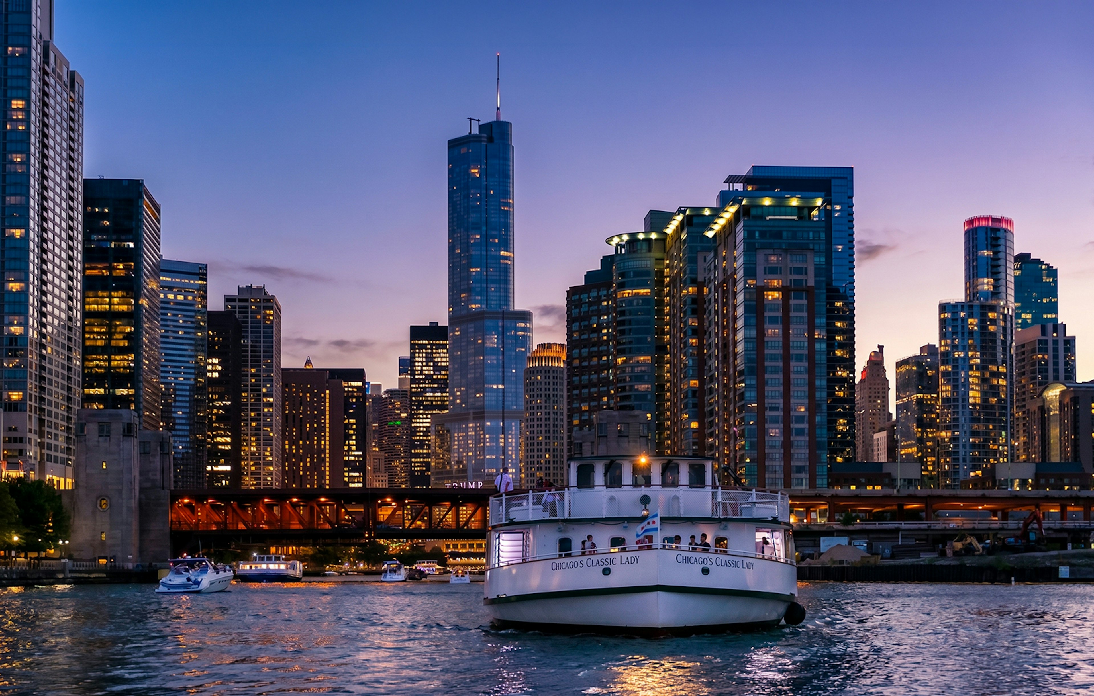 Chicago River cruise boat at night with city skyline in the background.