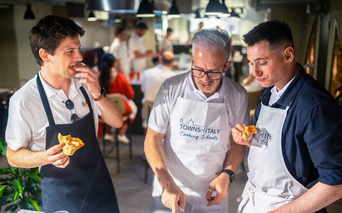 Participants enjoying pizza during a cooking class in Milan.