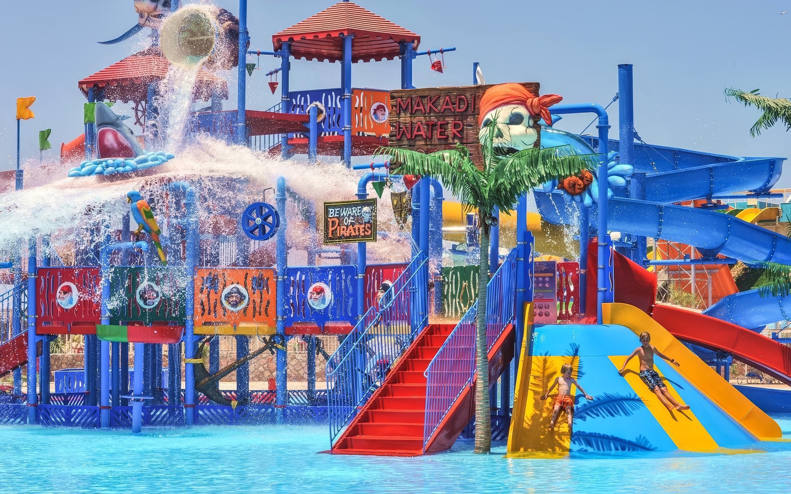 Pirate-themed slides at Makadi Water World, Hurghada with children playing.