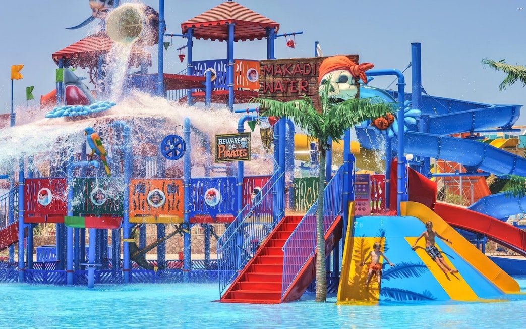 Pirate-themed slides at Makadi Water World, Hurghada with children playing.