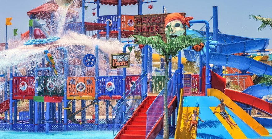 Pirate-themed slides at Makadi Water World, Hurghada with children playing.
