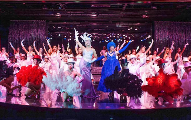 Performers in vibrant costumes on stage at Calypso Cabaret Show, Bangkok.