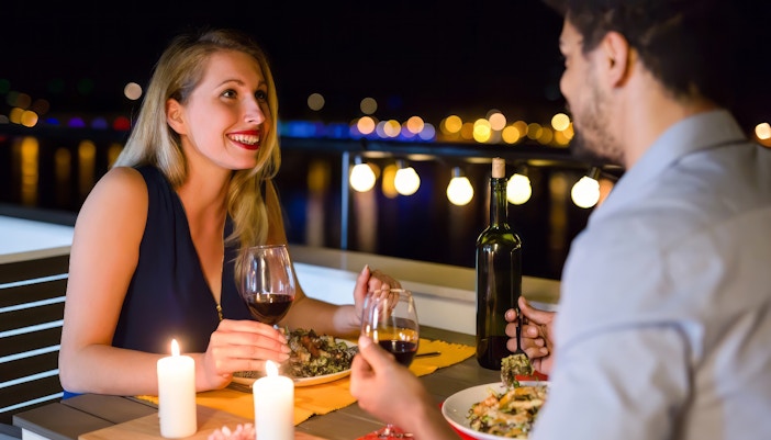 Couple dining on a romantic Valentine dinner cruise with Eiffel Tower view, Paris.