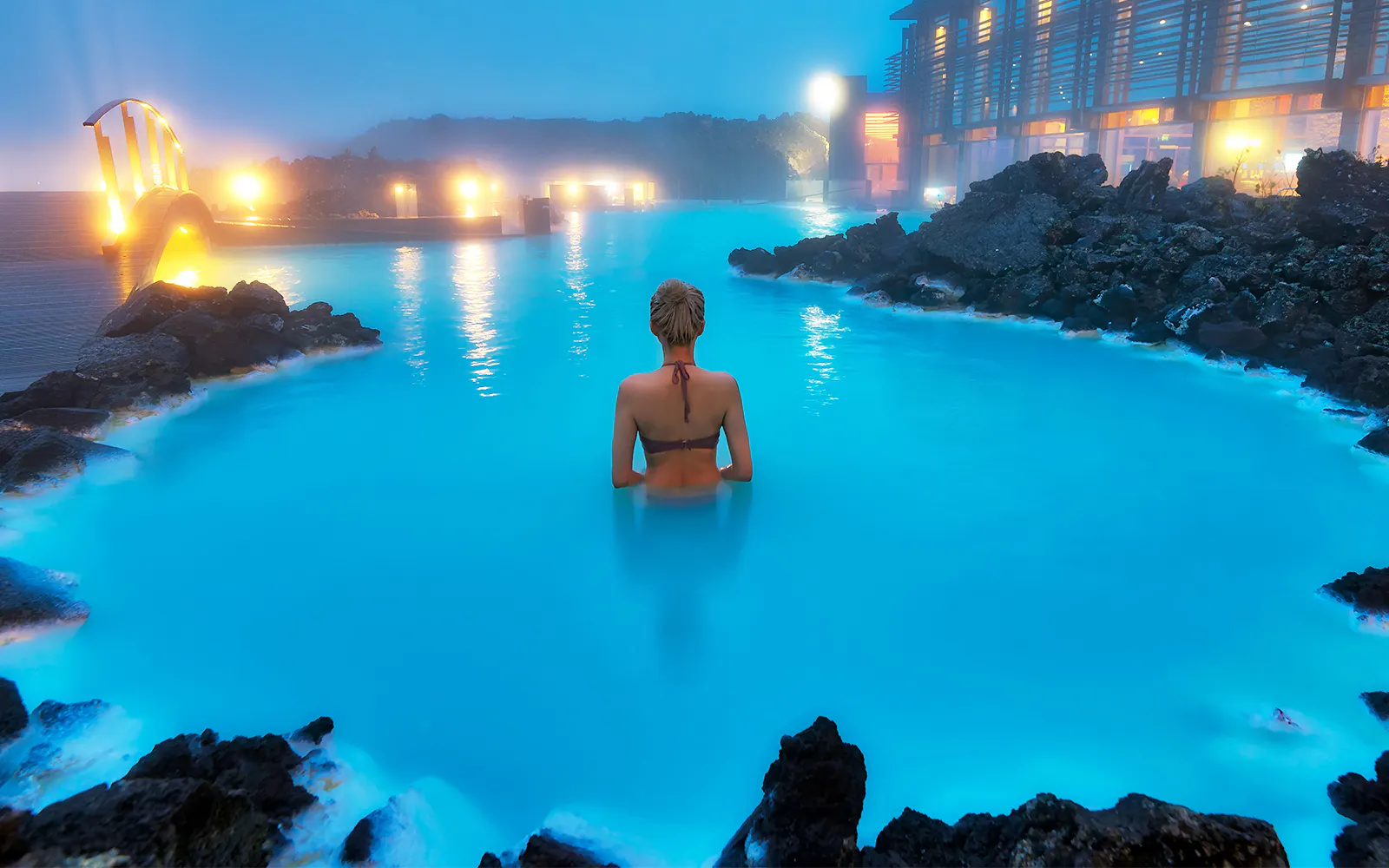 Person swimming in Blue Lagoon geothermal pool, Western Iceland.