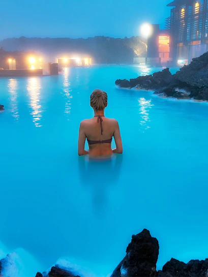 Person swimming in Blue Lagoon geothermal pool, Western Iceland.