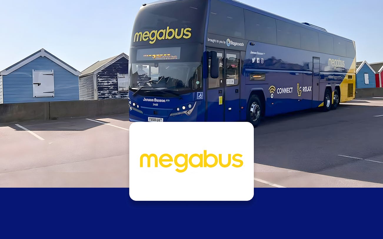 Double-decker Megabus parked near colorful beach huts, offering round-trip tickets between Heathrow Airport and London.