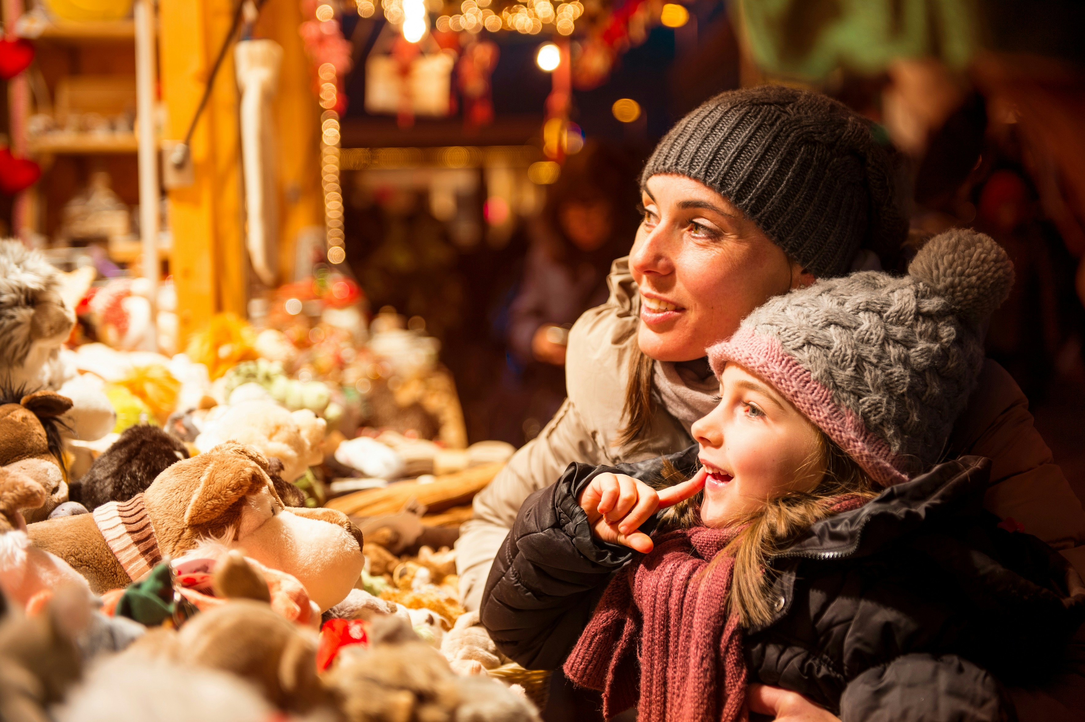 Mother and child admiring toys at a Christmas market stall.