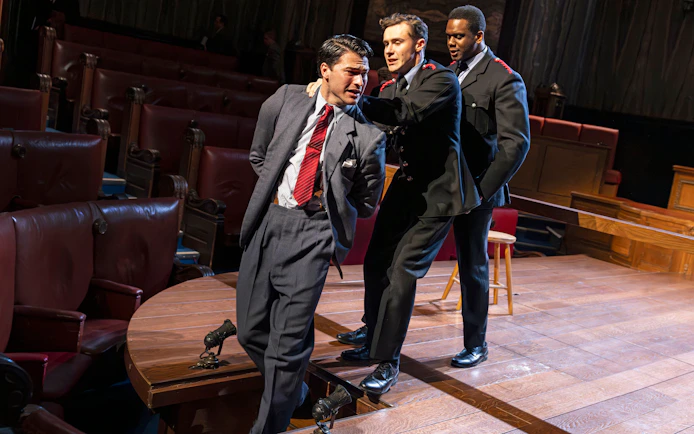Courtroom scene from "Witness for the Prosecution" performance with actors in dramatic pose.