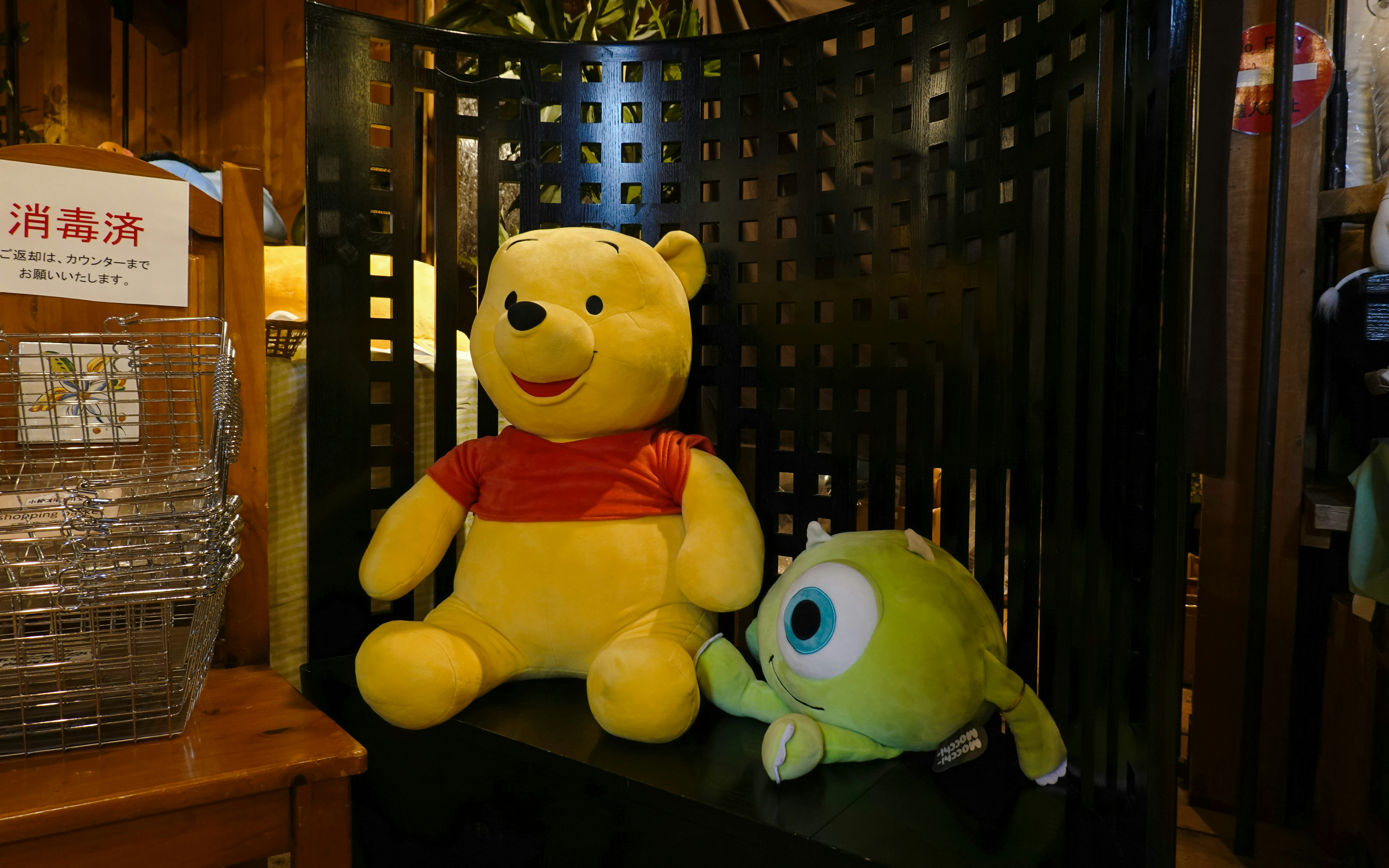 Winnie the Pooh and Mike Wazowski plush toys on display.
