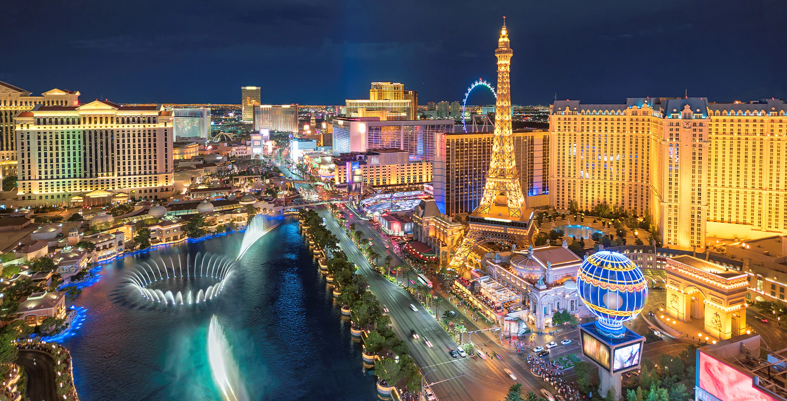 Las Vegas Strip at night with illuminated hotels, Eiffel Tower replica, and Bellagio fountains.