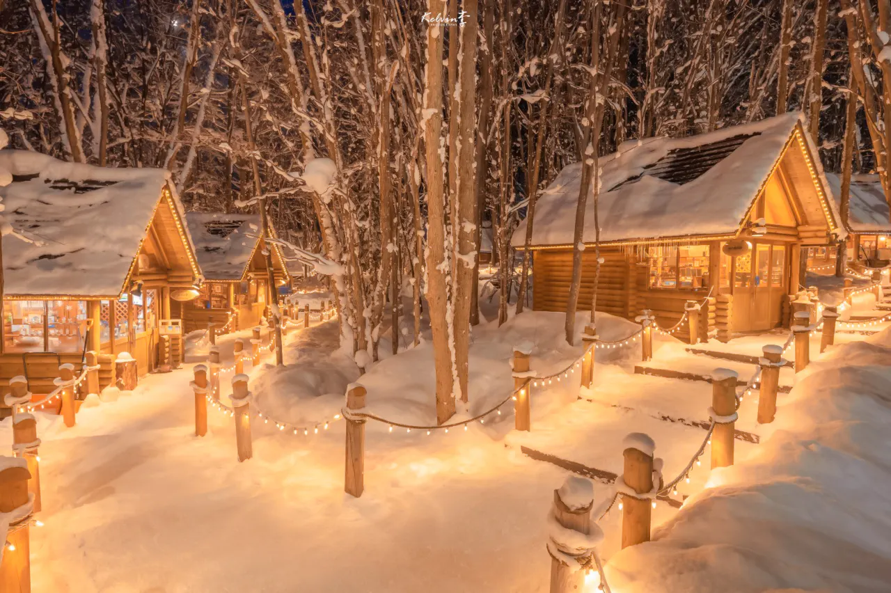 Snow-covered cabins illuminated at Ningle Terrace, Hokkaido.
