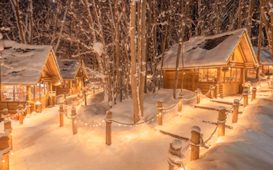 Snow-covered cabins illuminated at Ningle Terrace, Hokkaido.