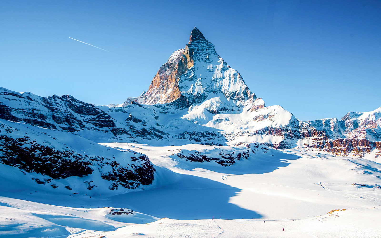 Matterhorn Glacier in Switzerland with snow-covered peaks and clear blue sky.