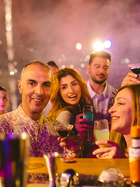 Guests enjoying drinks and music on Athens Riviera cruise, Greece.