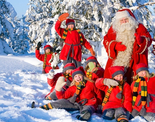 Children with Santa Claus in snowy Santa Claus Village, Rovaniemi.