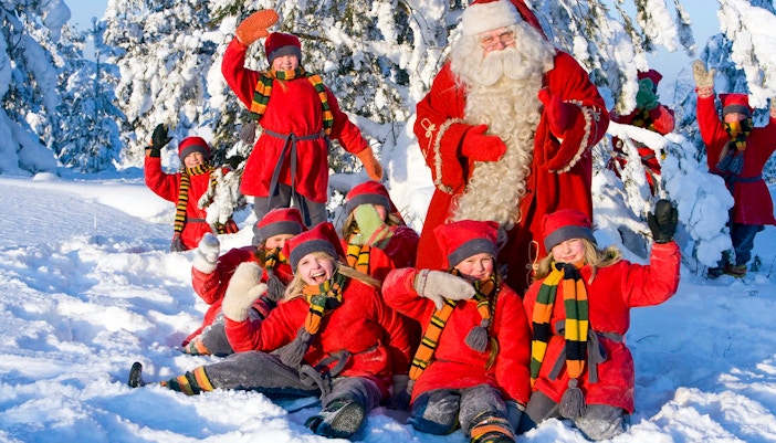 Children with Santa Claus in snowy Santa Claus Village, Rovaniemi.