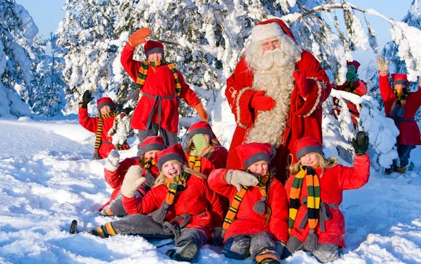 Children with Santa Claus in snowy Santa Claus Village, Rovaniemi.