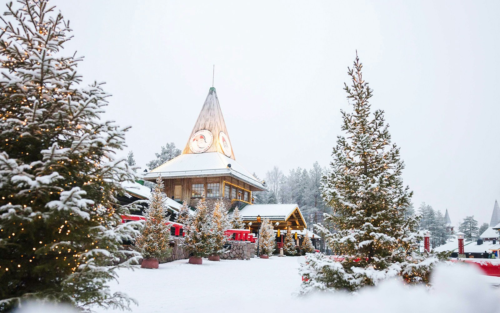 Santa Claus Village in Lapland with snow-covered trees and festive lights.