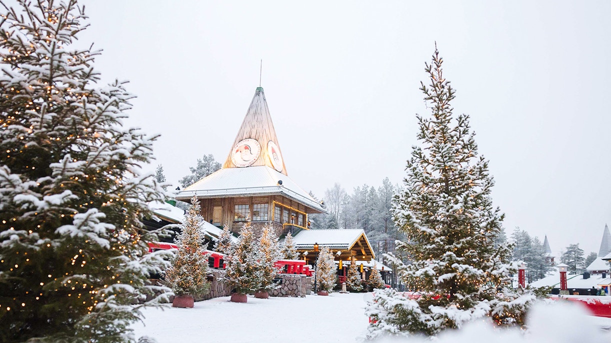 Santa Claus Village in Lapland with snow-covered trees and festive lights.