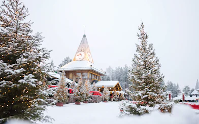 Santa Claus Village in Lapland with snow-covered trees and festive lights.