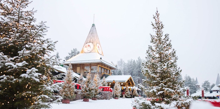 Santa Claus Village in Lapland with snow-covered trees and festive lights.