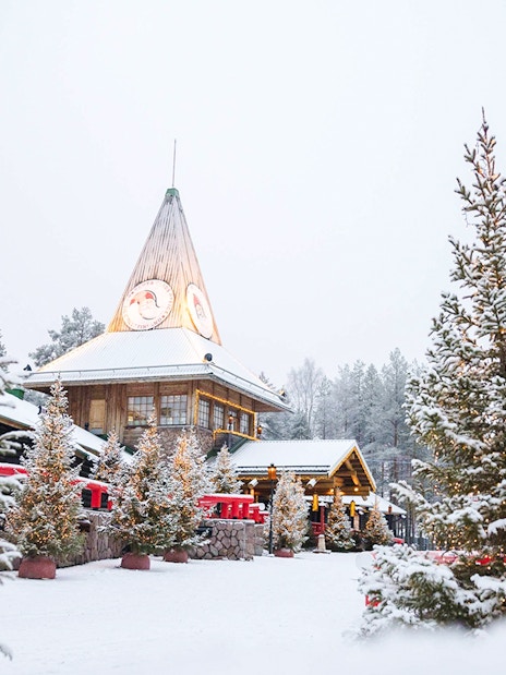 Santa Claus Village in Lapland with snow-covered trees and festive lights.