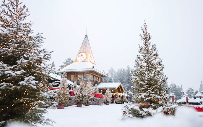 Santa Claus Village in Lapland with snow-covered trees and festive lights.