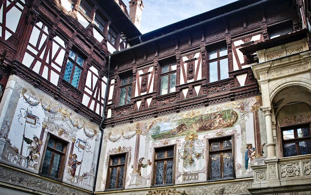 Peles Castle wall details with intricate frescoes and ornate woodwork.