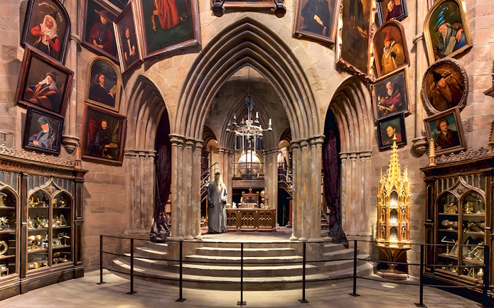 Costume exhibits in a hall at the Harry Potter London tour, featuring Dumbledore's office.
