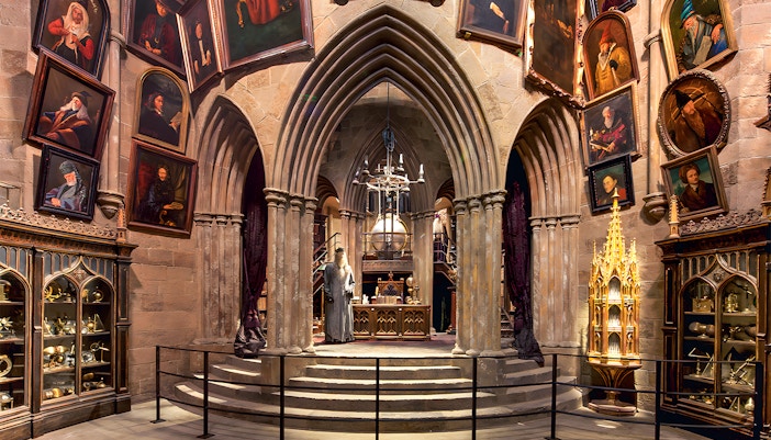 Costume exhibits in a hall at the Harry Potter London tour, featuring Dumbledore's office.