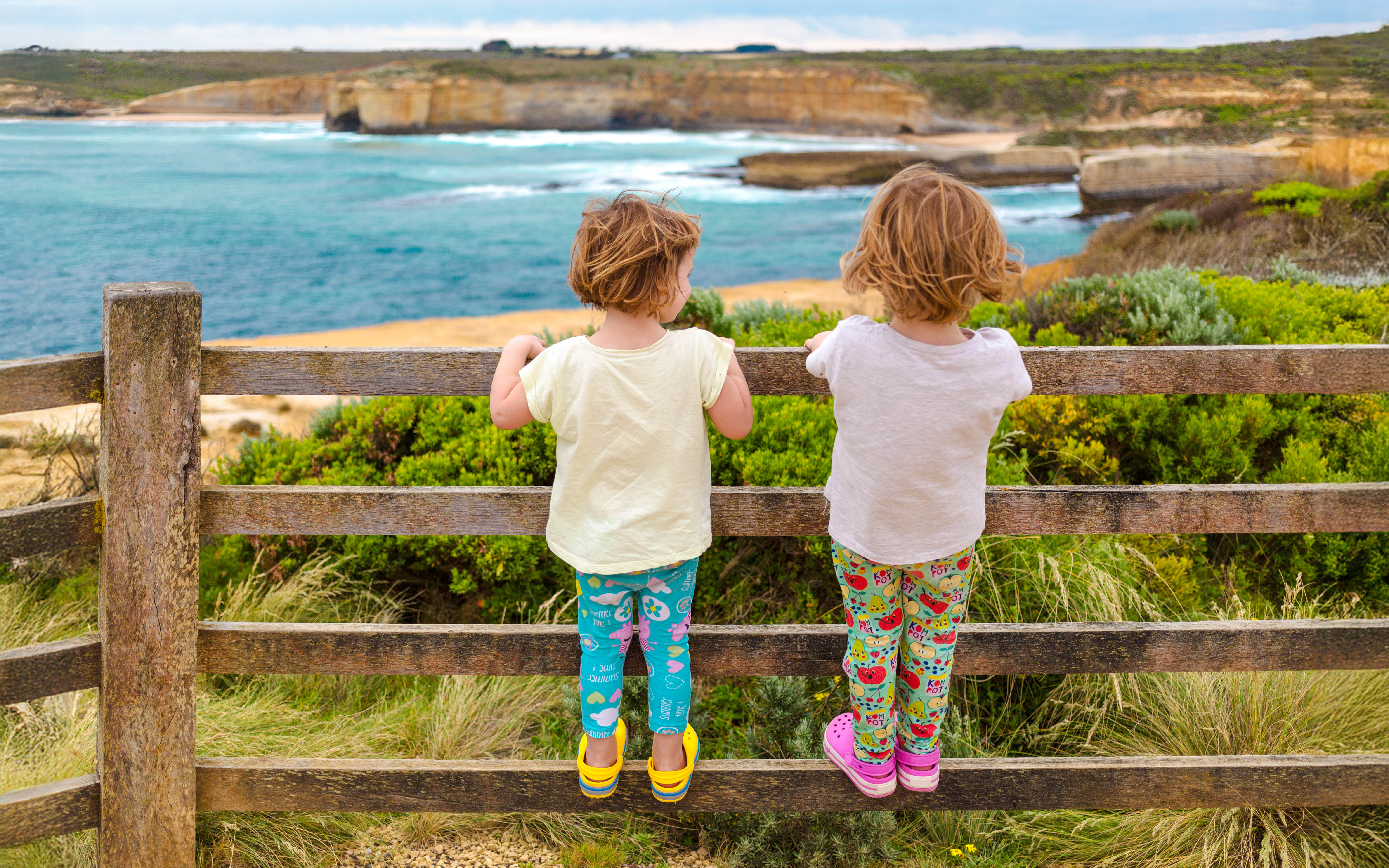 Children enjoying a scenic view along the Great Ocean Road, Australia.