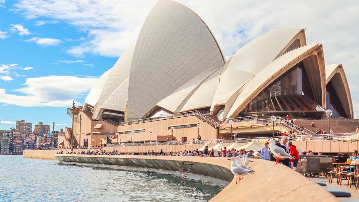 Sydney Opera House with visitors on the promenade during a guided tour.