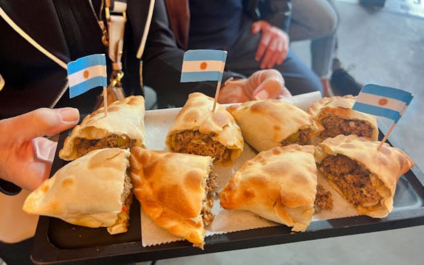 Tray of Argentine empanadas with small flags.