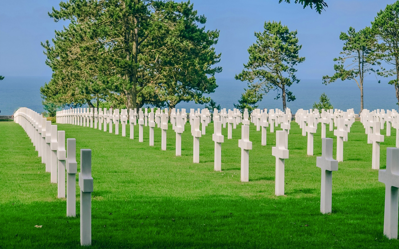 Rows of white crosses at Normandy American Cemetery, overlooking the sea in Caen, France.