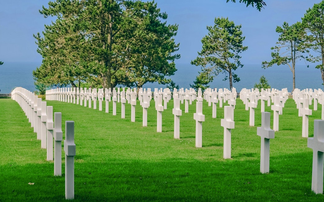 Rows of white crosses at Normandy American Cemetery, overlooking the sea in Caen, France.