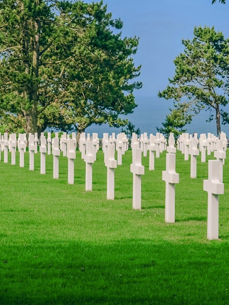 Rows of white crosses at Normandy American Cemetery, overlooking the sea in Caen, France.