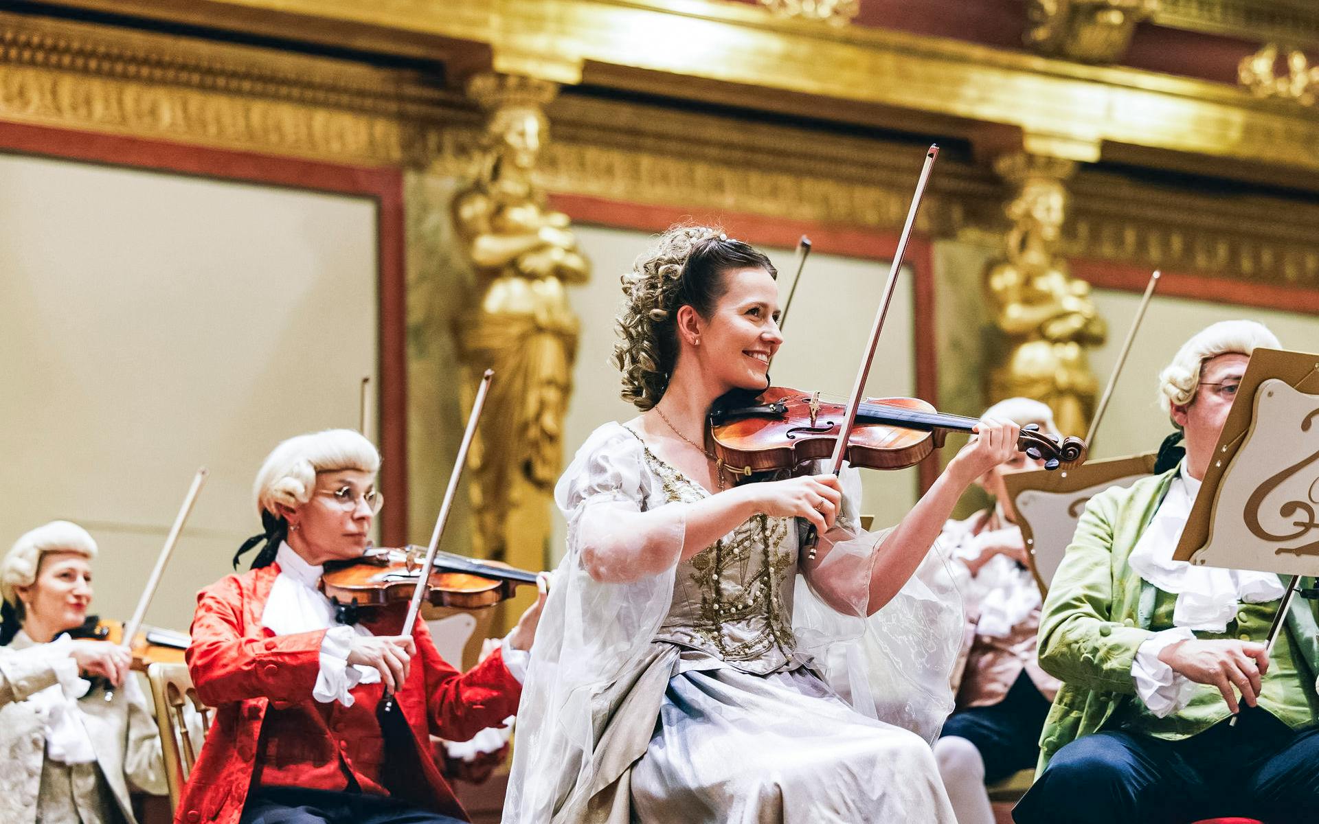 Musicians in period costumes performing at a Mozart orchestra concert.