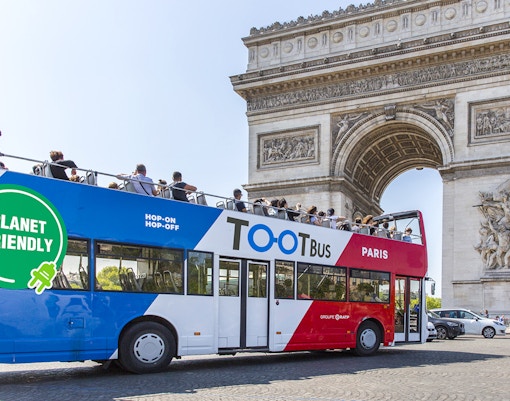 Open-top Tootbus touring past Eiffel Tower in Paris, France.