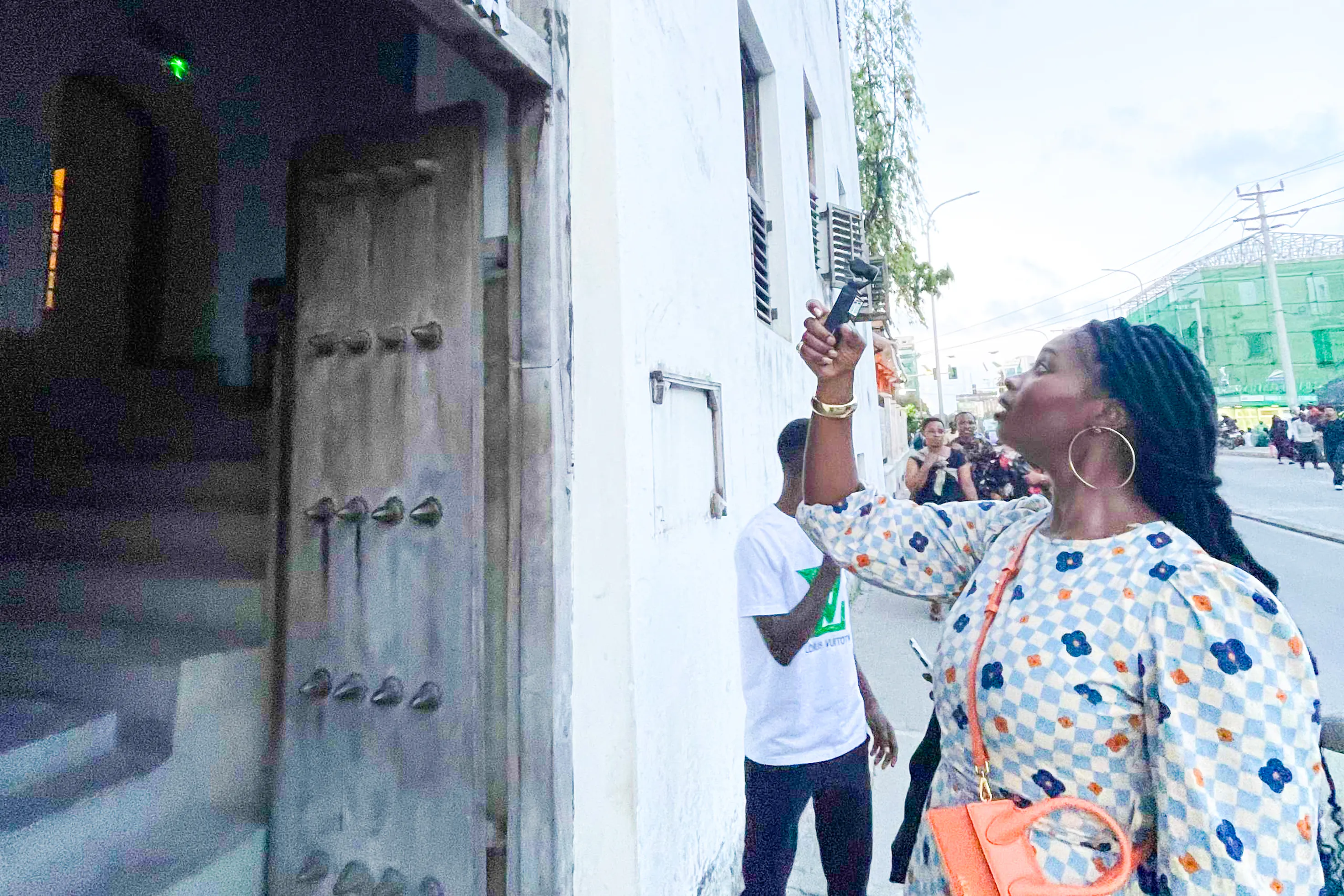 Tourist exploring Stone Town street with guide, Zanzibar.