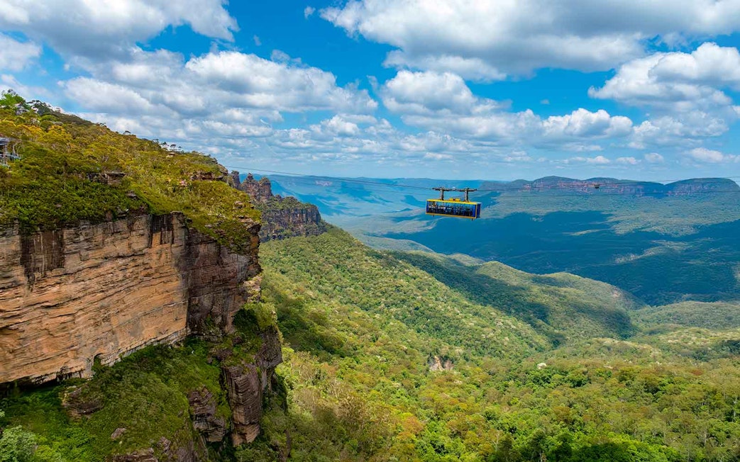 Cable car over Blue Mountains, Australia, with expansive forest and cliffs.